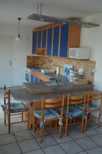uma cozinha com uma mesa de madeira e algumas cadeiras em Maison vue mer em Camaret-sur-Mer