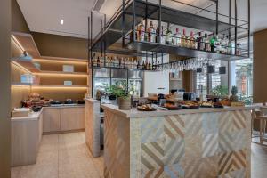 un restaurante con un bar que sirve comida y bebida en Brown Kubic, a member of Brown Hotels en Athens