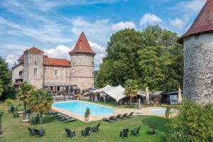 an external view of a castle with a swimming pool at Les Dépendances du Château Chapeau Cornu in Vignieu