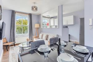 a living room with a table and chairs and a couch at Aryas Apartments London in London