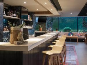 a bar with a row of stools in a restaurant at Swiss-Belinn Timika in Timika