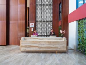 two people sitting in a lobby with their laptops at Swiss-Belinn Timika in Timika