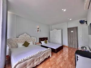 a bedroom with a large white bed and a table at Royal Homestay in Tuy Hoa