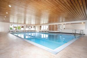a large swimming pool with a wooden ceiling at Ferienpark Oberallgäu Haus 1 in Missen-Wilhams