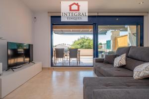 a living room with a couch and a tv at Casa Pool TimeOut in Palamós