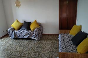een woonkamer met een bank met gele en zwarte kussens bij Casetta con camino per pellegrini e camminatori in Cantalice