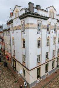 a white building with people standing in front of it at Apart Ivana Fedorova 30 in Lviv