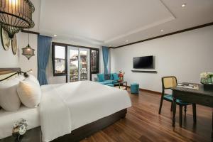 a bedroom with a large white bed and a desk at Media Central Hotel & Spa in Hanoi