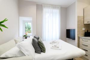 a white bedroom with a white couch and a television at Simply Perfect Apartment - NDP Rent in Rome