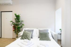 un sofá blanco con almohadas verdes en la sala de estar. en Simply Perfect Apartment - NDP Rent, en Roma