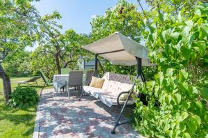 a patio with a couch and a white umbrella at Fantastic 170m2 Villa with a big garden in Pärnu