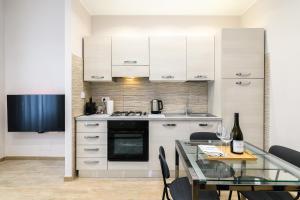 cocina con armarios blancos y mesa de cristal en Simply Perfect Apartment - NDP Rent, en Roma