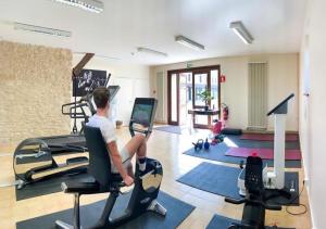 a man sitting on a treadmill in a gym at Les Dépendances de Chapeau Cornu in Vignieu