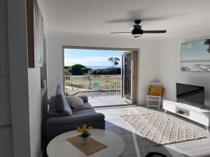 Oceanview في Woorim: غرفة معيشة مع أريكة وباب زجاجي منزلق