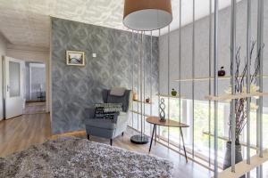 ein Wohnzimmer mit einem Sofa und einem Stuhl in der Unterkunft Fantastic 170m2 Villa with a big garden in Pärnu