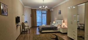 a bedroom with a bed and a tv and a window at ISR apart by Bakuapart in Baku