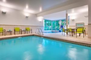 una piscina con sillas y una mesa en una habitación en SpringHill Suites by Marriott Salt Lake City Draper en Draper