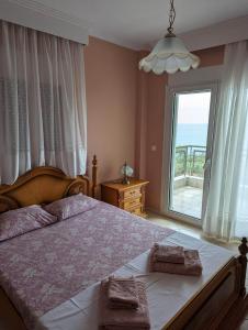 a bedroom with a large bed and a large window at Lichnides Maisonette in Mola Kalyva