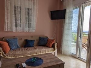 a living room with a couch and a large window at Lichnides Maisonette in Mola Kalyva