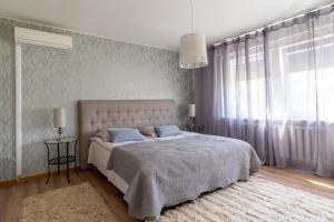 a bedroom with a large white bed with blue pillows at Fantastic 170m2 Villa with a big garden in Pärnu