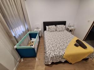1 Schlafzimmer mit einem schwarzen und weißen Bett und 2 Tischen in der Unterkunft habitacion con baño privado en un piso con familia in Santa Cruz de la Palma