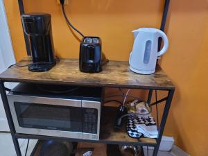 a table with a microwave and a coffee maker on it at The Spot in Stonehurst