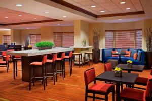 a restaurant with a bar and tables and chairs at Courtyard by Marriott Toronto Airport in Toronto