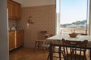 cocina con mesa, sillas y ventana en Il Girasole, en Módica