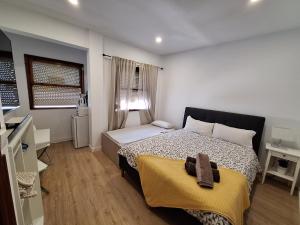 a bedroom with a bed with a yellow blanket on it at habitacion con baño privado en un piso con familia in Santa Cruz de la Palma