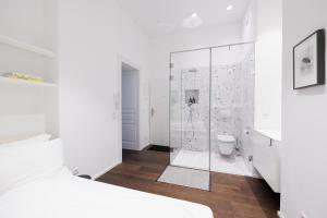 a white bedroom with a shower and a toilet at Design Apartment Spittelberg - 7th district - contactless checkin in Vienna