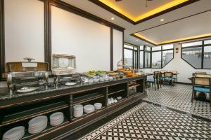 a restaurant with a buffet line with dishes at Media Central Hotel & Spa in Hanoi