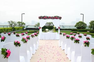 a row of white chairs with pink flowers at Langham Place Guangzhou - Walking distance to Canton Fair in Guangzhou