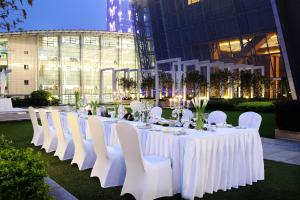 a long white table with white chairs and tablesearcher at Langham Place Guangzhou - Walking distance to Canton Fair in Guangzhou