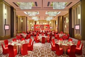 a large banquet hall with tables and red chairs at Langham Place Guangzhou - Walking distance to Canton Fair in Guangzhou