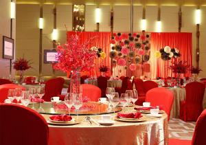 a dining room with a table and red chairs at Langham Place Guangzhou - Walking distance to Canton Fair in Guangzhou
