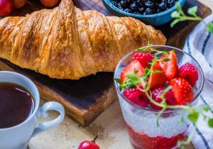 a table with a loaf of bread and a bowl of strawberries at La chambre de l'abreuvoir in Bergicourt