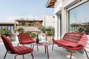 patio z 2 krzesłami i stołem na balkonie w obiekcie Palazzo Delle Pietre - Luxury Apartments w Rzymie