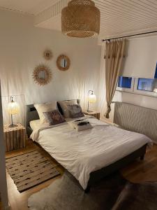a bedroom with a large white bed with two lamps at Appartement jerry et joy in Wolfisheim