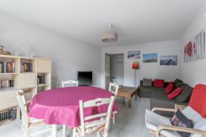 a living room with a table and a couch at Appart Tout Confort in Guillestre