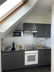 a kitchen with black and white cabinets and a sink at Appartement jerry et joy in Wolfisheim