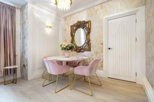 uma sala de jantar com uma mesa, cadeiras e um espelho em 1LSR - High-End Luxury 2 Bed Designer Apartment em Londres