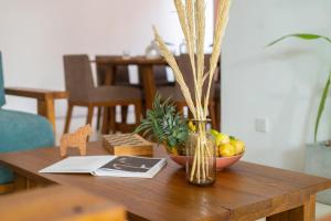 a wooden table with a vase and a bowl of fruit at NETS Cowork & Colive in Ahangama