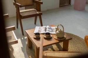a table with two cups and a tea set on it at NETS Cowork & Colive in Ahangama