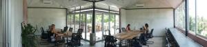 a dining room with tables and chairs and windows at NETS Cowork & Colive in Ahangama