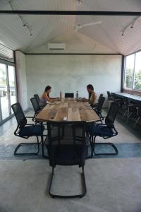 two women sitting at a large wooden table in a room at NETS Cowork & Colive in Ahangama
