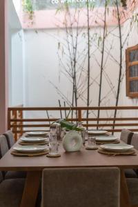 a wooden table with plates and glasses on it at NETS Cowork & Colive in Ahangama