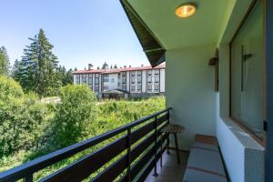 a balcony with a view of a building at Villa Kometa Pamporovo Cozy 1-BD Flat by Flat Mаnager in Pamporovo