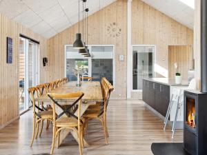eine Küche und ein Esszimmer mit einem Holztisch und Stühlen in der Unterkunft Holiday home Bogense XLII in Bogense