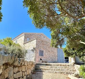 Casa de piedra con pared de piedra y escaleras en Villa Maria Cristina, en Santa Teresa Gallura