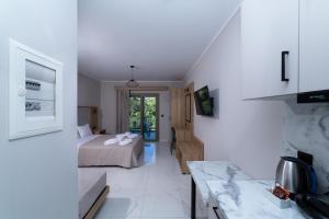 a white room with a bed and a kitchen at Sky View Suites Kefalonia in Vóvikes